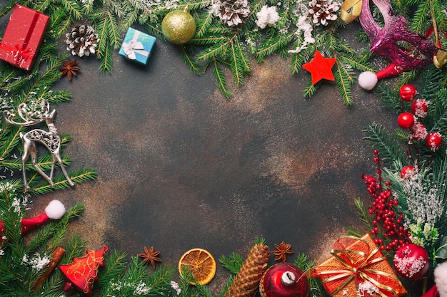 Christmas gifts, pine branches, toys and santa hat on stone