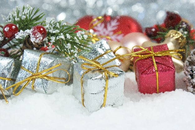 Christmas gifts and pine tree branch nestled in snow