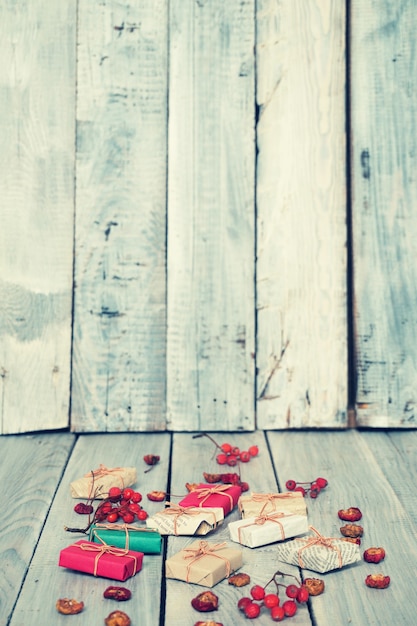 Foto regali di natale, sorbo, noci, sparsi su tavole bianche dipinte ruvide
