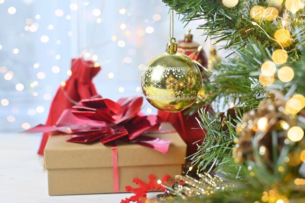 Рождественские подарки и сюрпризы на белом деревянном столе рядом с ветвями елки