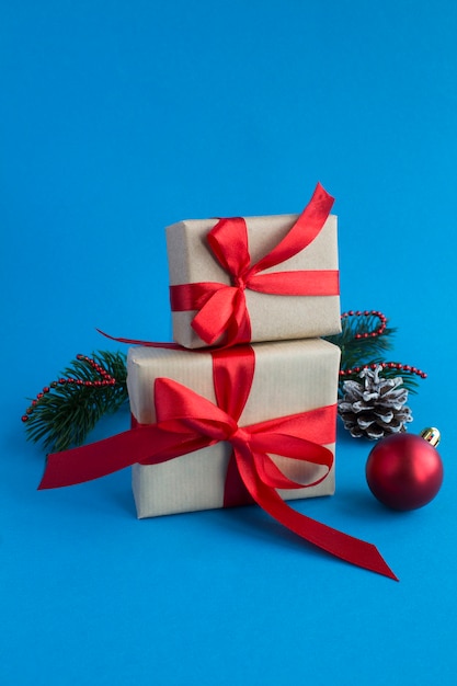 Christmas gifts with tied red bow on the blue background. Close-up.