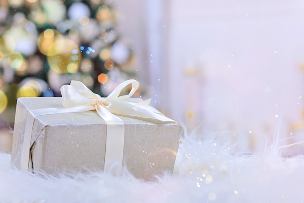 写真 クリスマスツリーの下の白いリボンとクリスマスプレゼント。
