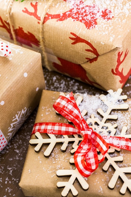 Christmas gifts wrapped in brown paper with red ribbons.