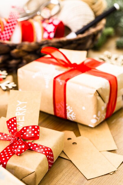 Christmas gifts wrapped in brown paper with red ribbons.