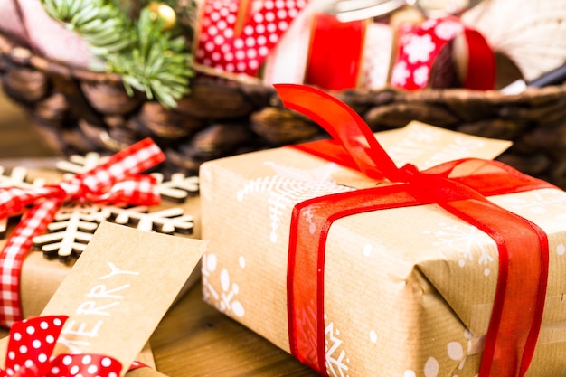 Christmas gifts wrapped in brown paper with red ribbons.