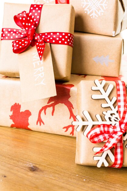 Christmas gifts wrapped in brown paper with red ribbons.