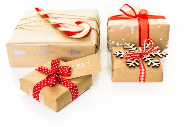 Christmas gifts wrapped in brown paper with red ribbons.