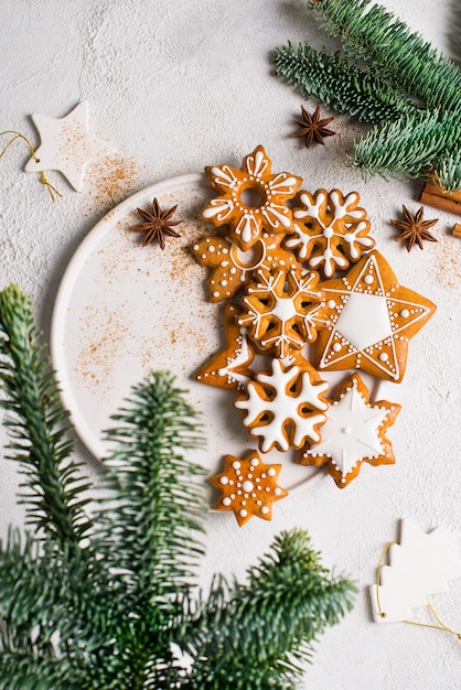 Biscotti del fondo del pan di zenzero di natale con l'abete, pino, sul concetto di vacanza di felice anno nuovo di struttura bianca, verticale