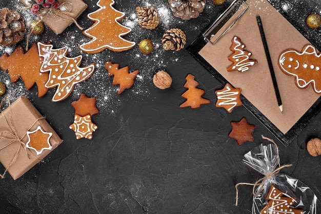 A christmas gingerbread cookie in the shape of a christmas tree in a cellophane packing on the backg...