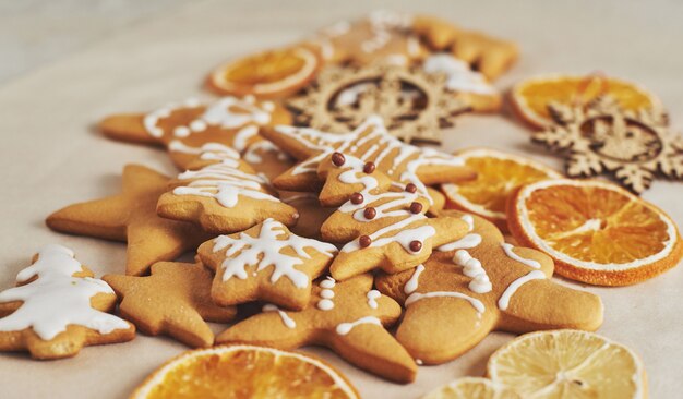 Christmas gingerbread cookies and dried orange and spices on white table