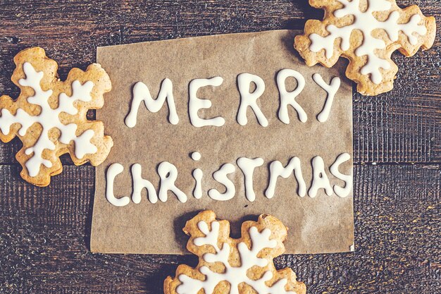 Photo christmas gingerbread cookies and inscription on a dark background with the effect instagram