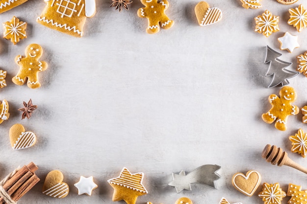 Christmas gingerbread cookies lie on the table together with cinnamon and pine cones - copy space.