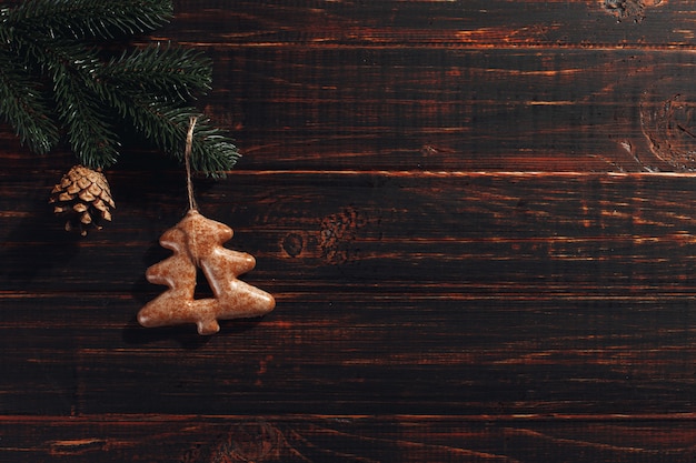 Christmas gingerbread cookies and pine branches and cones on a wooden , copyspace.