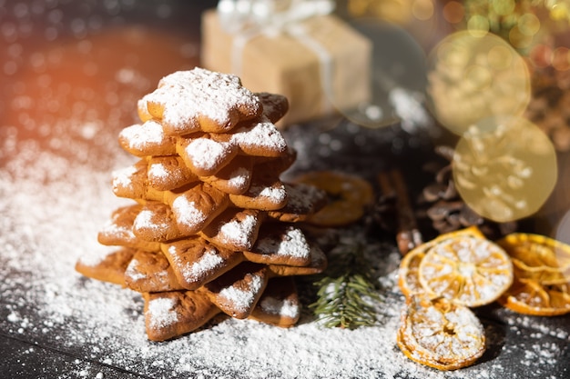 Albero di biscotti di panpepato di natale, frutta dolce essiccata decorata con zucchero in polvere dolce. cartolina di buon natale.