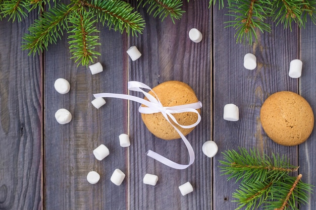 Christmas Gingerbread cookies with decorations and marshmallows on background with christmas tree.