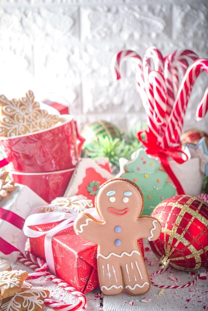 Christmas gingerbread cookies, with festive mugs for hot chocolate, Christmas decor and baubles, white background copy space