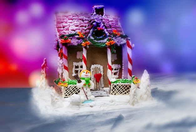 Christmas gingerbread house decoration on background of defocused lights. Mockup for seasonal offers and holiday post card