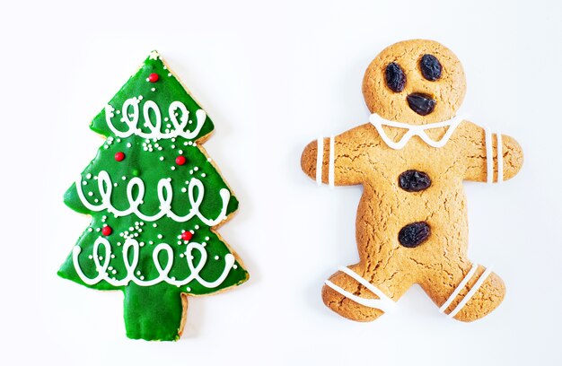 Christmas gingerbread man cookie and Christmas tree cookie isolated on white background.