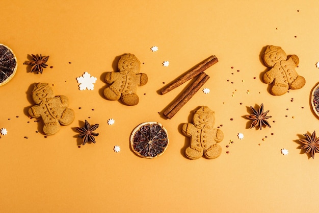 Christmas Gingerbread Men with fragrant spices. Traditional festive New Year decor. Trendy hard light, dark shadow, beige background, flat lay, close up