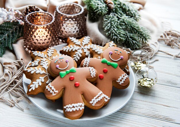 Christmas gingerbread in the plate and candles on white wooden background. Top view.