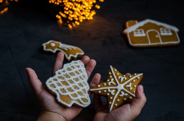 Christmas gingerbread with white icing sugar painted on a dark background.