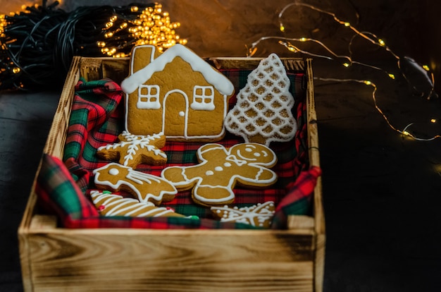 Christmas gingerbread with white icing sugar painted on a dark background.