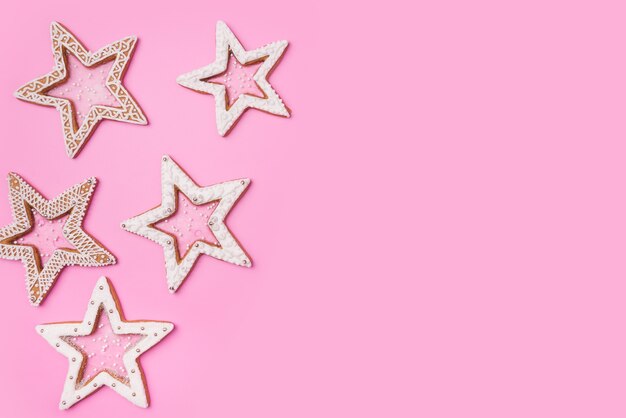 Photo christmas gingerbreads stars on sweet pink background.top view.