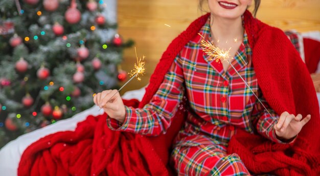 Christmas, girl with sparklers in hands. Selective focus. Holiday.