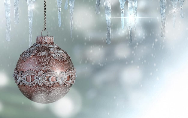 Рождественский стеклянный шар и сосульки на голубовато-изумрудном расфокусированном снежном фоне избирательный фокус