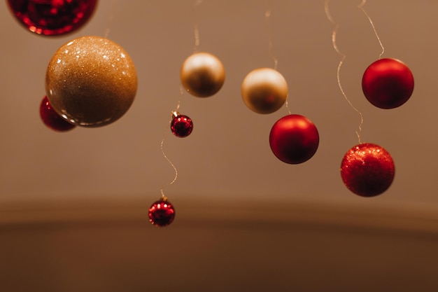 Christmas glass red and golden balls hanging in the interior on beige background New Year details