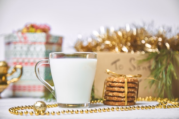 テーブルの上のサンタのためのミルクとクッキーとクリスマスグラス