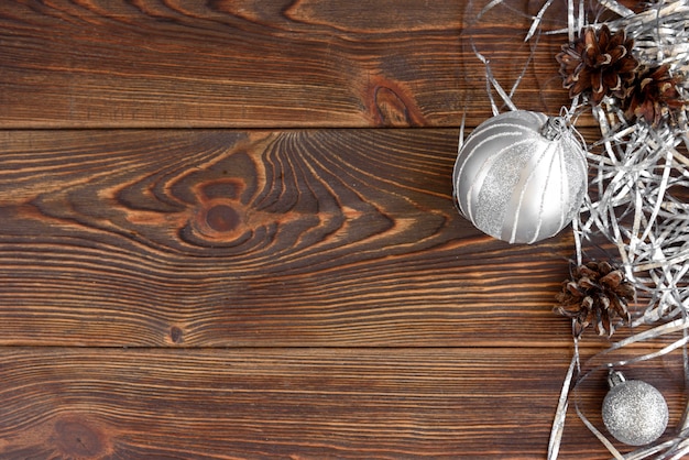 Christmas globes and cones on wooden board