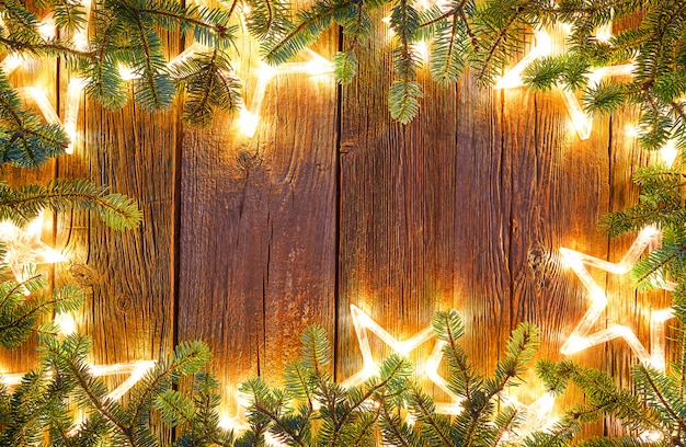 Christmas glowing stars and fir on wood