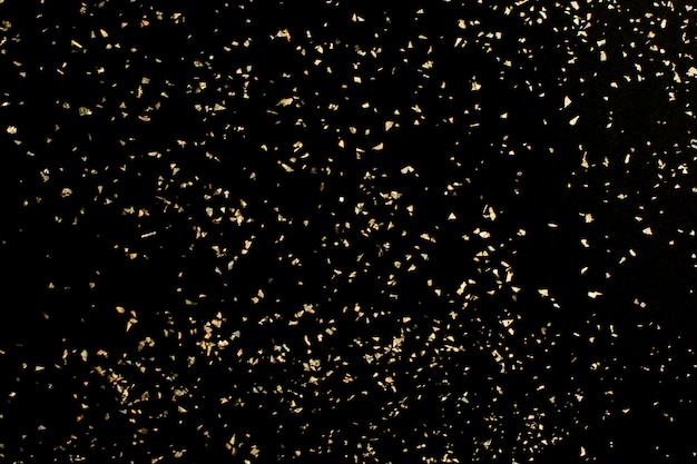 Christmas Gold glitter on black background. Holiday abstract texture