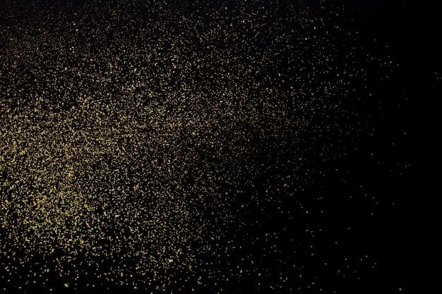 Christmas Gold glitter on black background. Holiday abstract texture