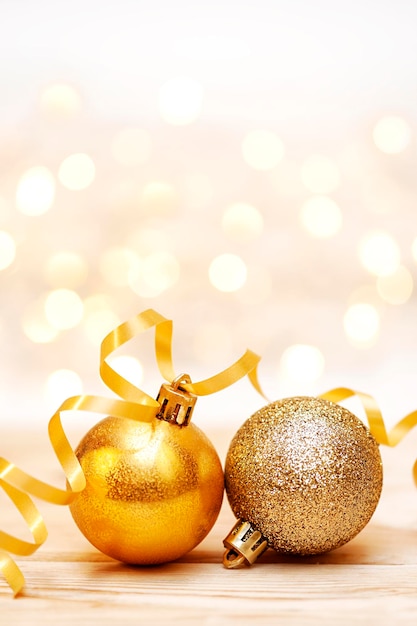 焦点がぼけた光の背景にクリスマスの金の装飾品垂直写真