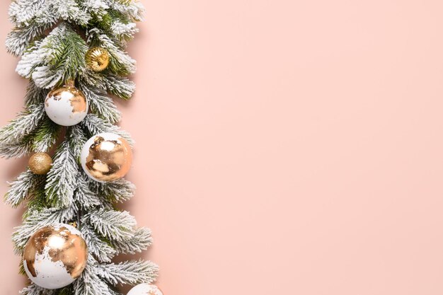 Christmas gold and white luxury baubles and snowy branches on pink background