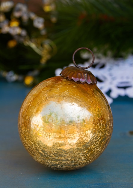 Foto sfera dorata di natale che pone sotto l'albero di abete