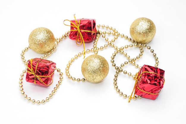 Christmas golden balls and gifts in red packaging tied by a chain on an isolated white background