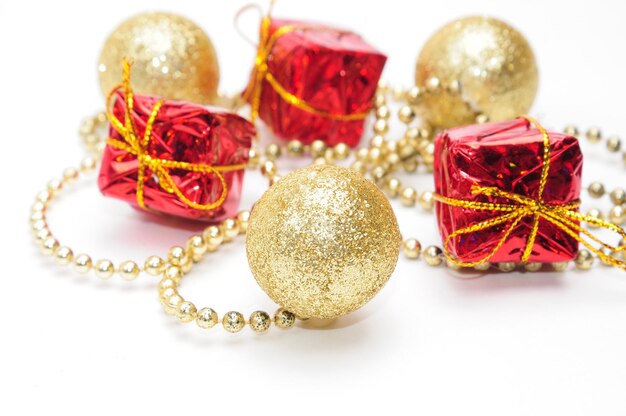 Christmas golden balls and gifts in red packaging tied by a chain on an isolated white background