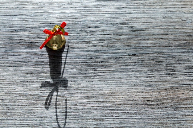 Christmas golden bell on a wooden surface