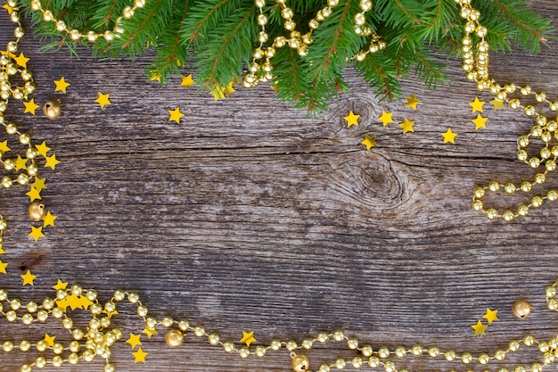 Decorazioni dorate di natale e cornice dell'albero di abete su legno