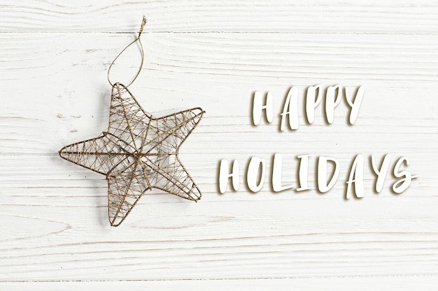 Christmas golden star on stylish white rustic wooden background space for text holiday greeting card concept unusual creative top view