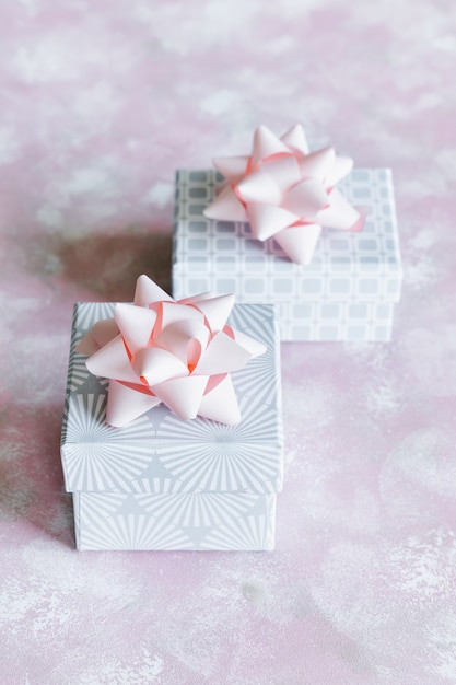 Foto scatole regalo di natale grigio con fiocchi rosa