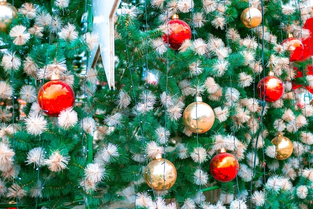 Foto abete verde di natale con decorazioni festive e ghirlande. felice anno nuovo e natale. sfondo luminoso per cartoline