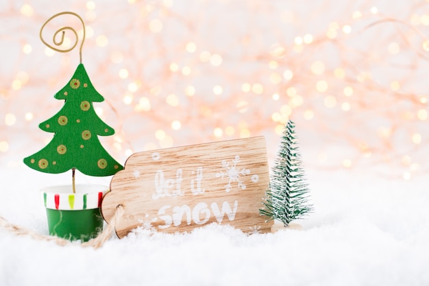 Christmas greeting card. Christmas tree branch on glitter golden bokeh lights background.