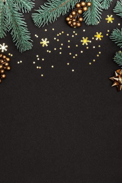 Christmas greeting card  with fir tree branches, golden stars and snowflakes on black.