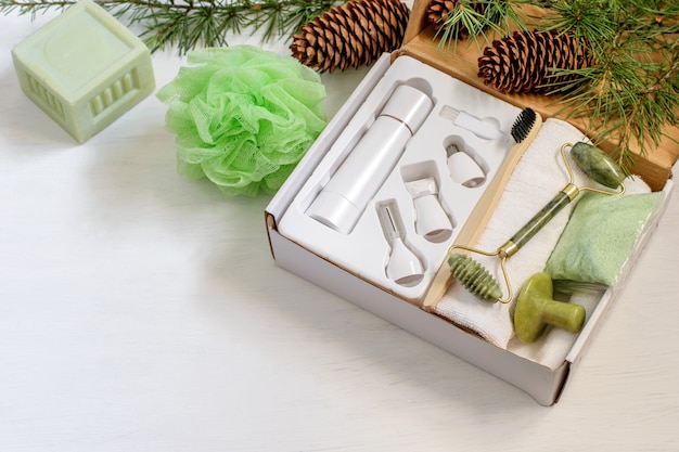 Photo christmas handmade gift box with natural eucalyptus spa cosmetics and face massager prepared for family or friends