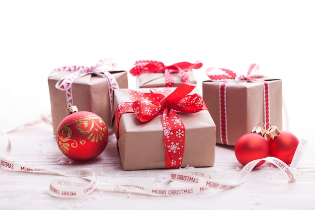 Christmas handmade presents with red ribbon on white wooden background