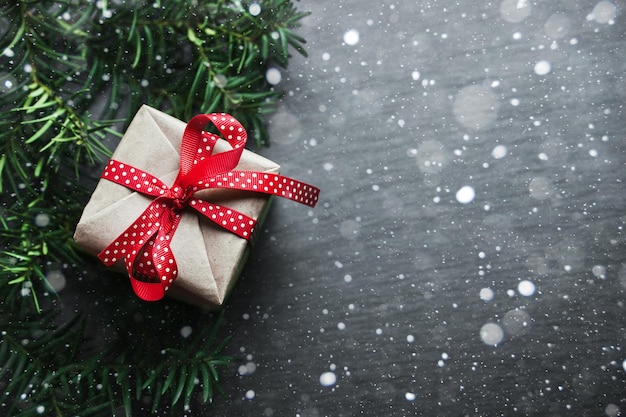 Christmas handmade presents with red ribbon on wooden background